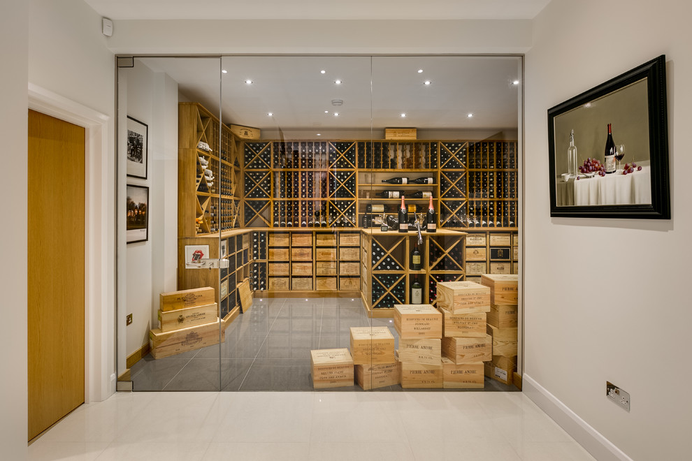 Inspiration for an expansive modern wine cellar in London with porcelain floors, storage racks and grey floor.