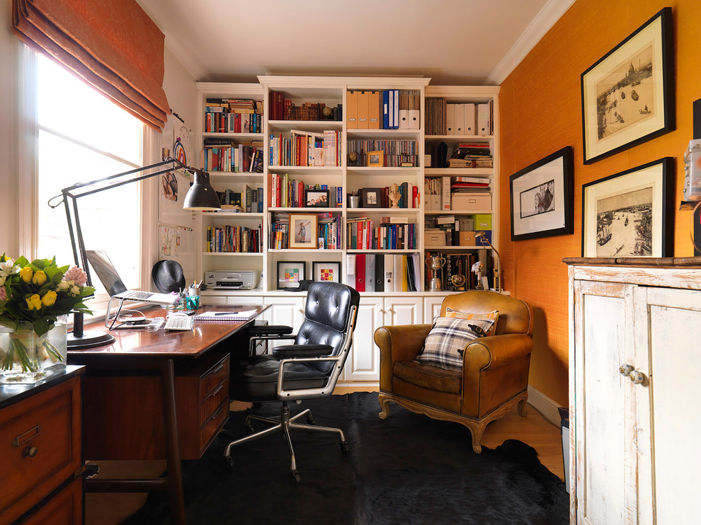 This is an example of a small traditional study room in London with orange walls, no fireplace, a freestanding desk and medium hardwood floors.