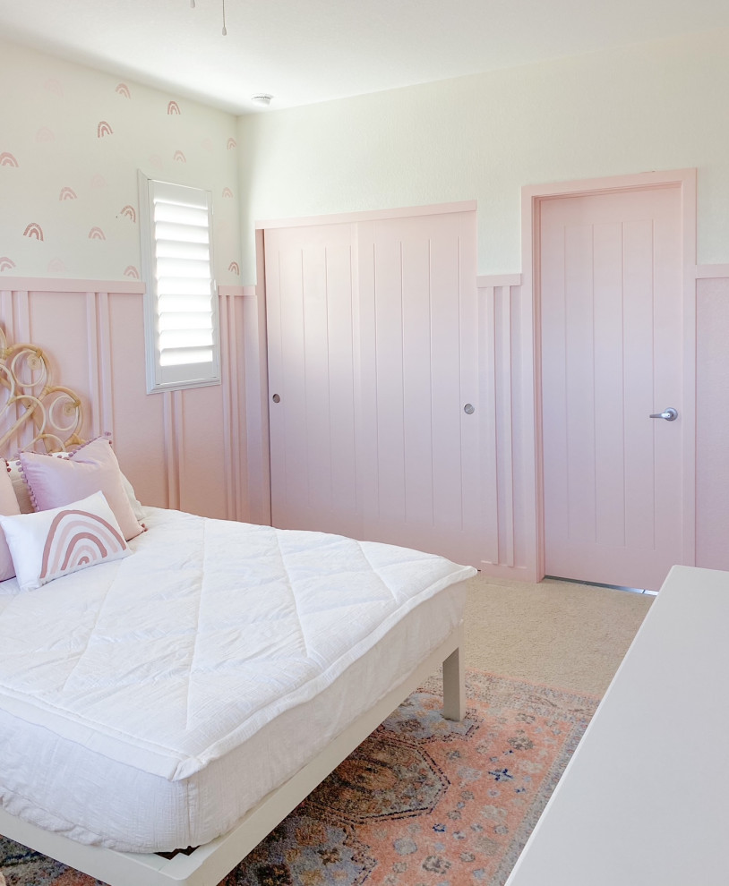 This is an example of a country kids' room for girls in Denver with pink walls and decorative wall panelling.