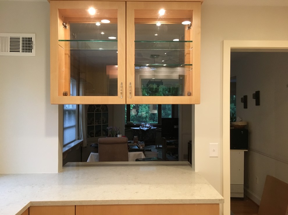 Inspiration for a mid-sized transitional u-shaped porcelain tile and gray floor enclosed kitchen remodel in DC Metro with an undermount sink, flat-panel cabinets, medium tone wood cabinets, quartz countertops, white backsplash, porcelain backsplash, stainless steel appliances and no island
