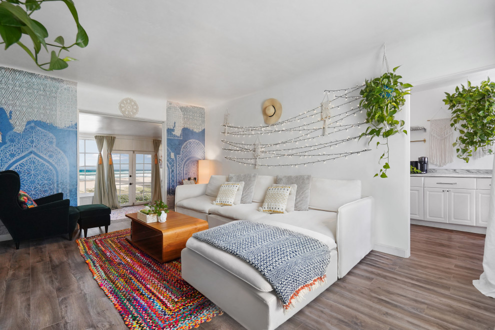 Ejemplo de salón abierto mediterráneo de tamaño medio con paredes blancas, suelo de madera en tonos medios y suelo multicolor