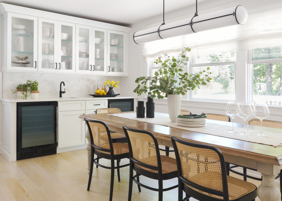 Foto di una grande sala da pranzo aperta verso la cucina chic con parquet chiaro e pavimento bianco