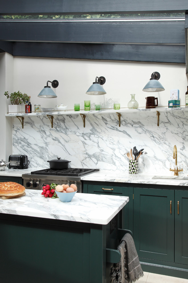 Contemporary galley eat-in kitchen in London with a drop-in sink, green cabinets, marble benchtops, marble splashback, stainless steel appliances, limestone floors, with island, recessed-panel cabinets, white splashback and white benchtop.