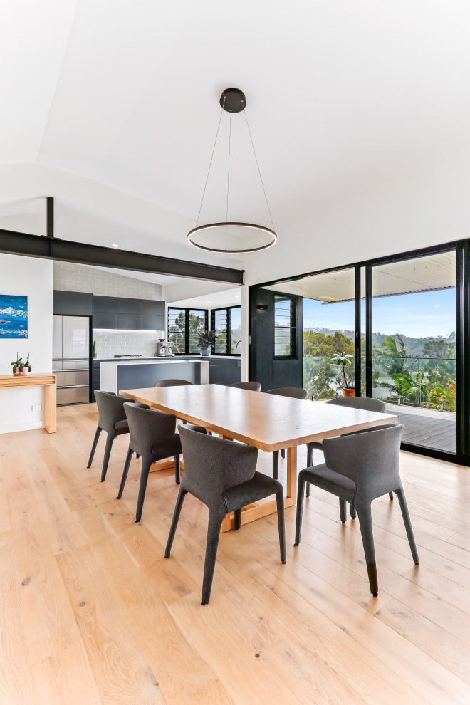 Photo of a contemporary open plan dining in Central Coast with white walls, medium hardwood floors, no fireplace and brown floor.
