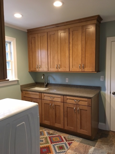 Design ideas for a mid-sized arts and crafts galley utility room in Other with an undermount sink, shaker cabinets, medium wood cabinets, quartz benchtops, green walls, slate floors and a side-by-side washer and dryer.
