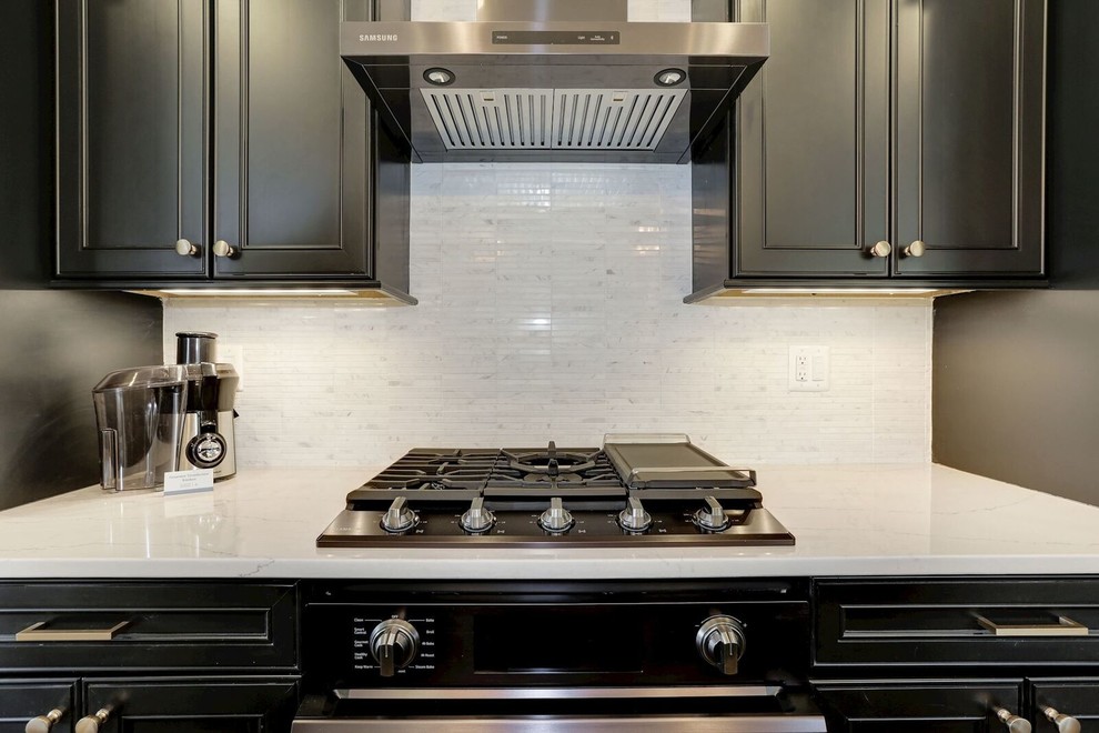 Small transitional single-wall medium tone wood floor and brown floor eat-in kitchen photo in Baltimore with an undermount sink, black cabinets, quartz countertops, white backsplash, ceramic backsplash, stainless steel appliances, an island, white countertops and flat-panel cabinets