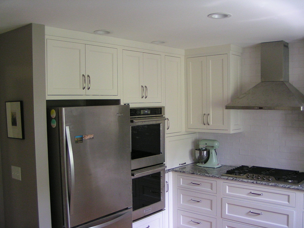 Mid-sized transitional u-shaped medium tone wood floor open concept kitchen photo with a double-bowl sink, shaker cabinets, white cabinets, granite countertops, gray backsplash, subway tile backsplash, stainless steel appliances and an island