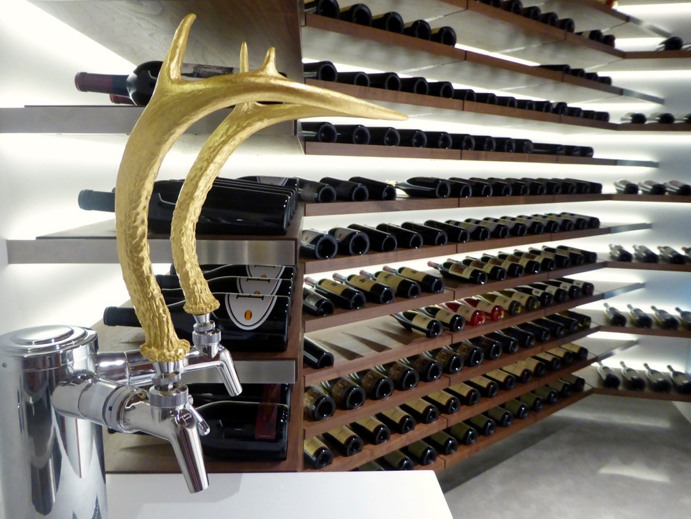 This is an example of a small contemporary wine cellar in Portland with concrete floors and display racks.