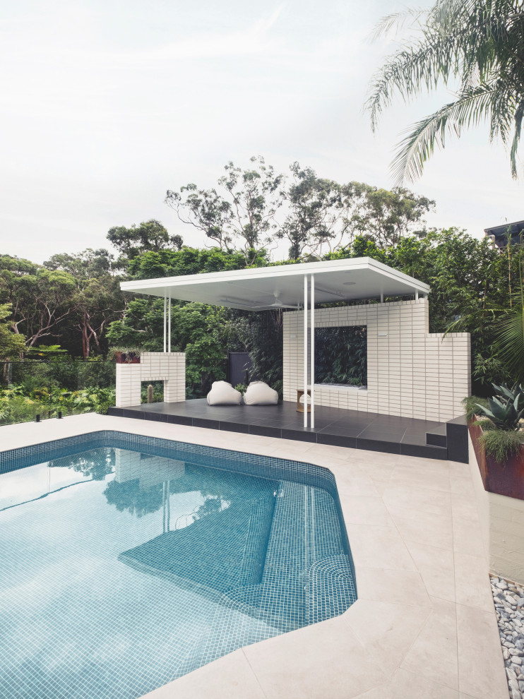 Inspiration for a small midcentury backyard custom-shaped pool in Sydney with tile.