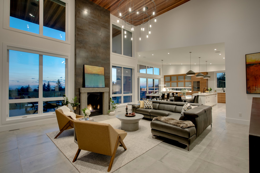 Large modern open concept living room in Calgary with white walls, ceramic floors, a standard fireplace, a metal fireplace surround, a built-in media wall and grey floor.