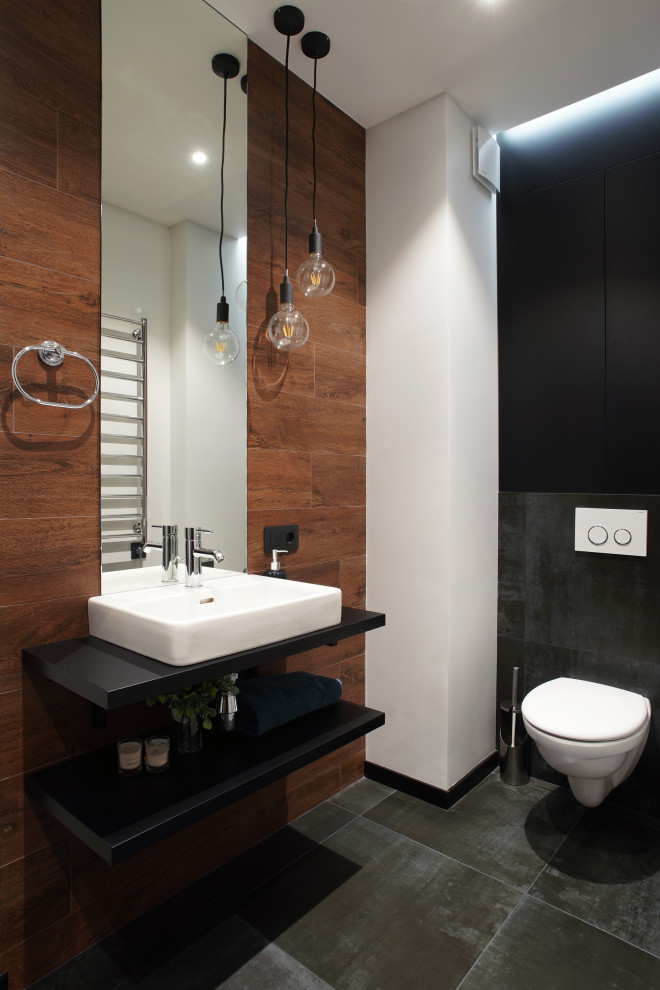 Small contemporary 3/4 bathroom in Saint Petersburg with flat-panel cabinets, black cabinets, an alcove shower, a wall-mount toilet, black tile, porcelain tile, multi-coloured walls, porcelain floors, a drop-in sink, laminate benchtops, black floor, a hinged shower door, black benchtops, a single vanity and a floating vanity.