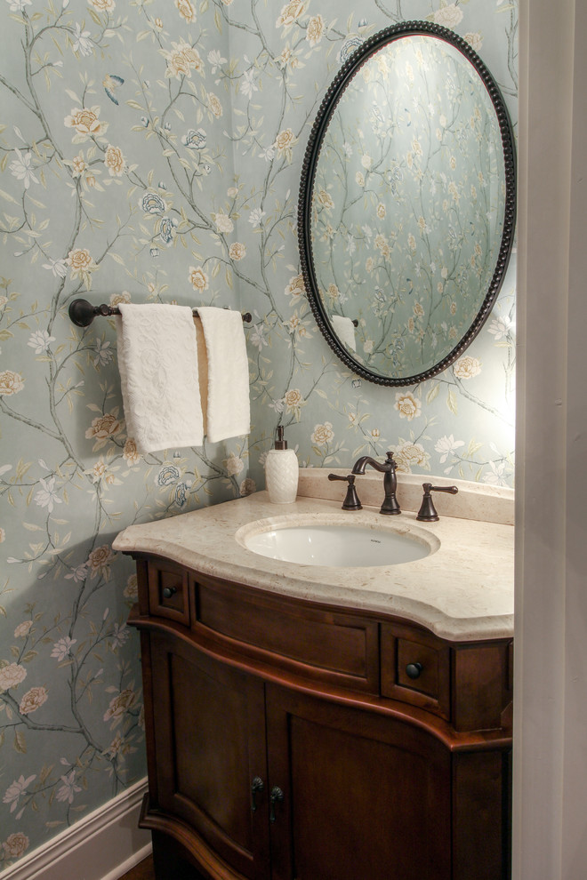 This is an example of a mid-sized transitional powder room in Indianapolis with furniture-like cabinets, dark wood cabinets, blue walls, an undermount sink and marble benchtops.