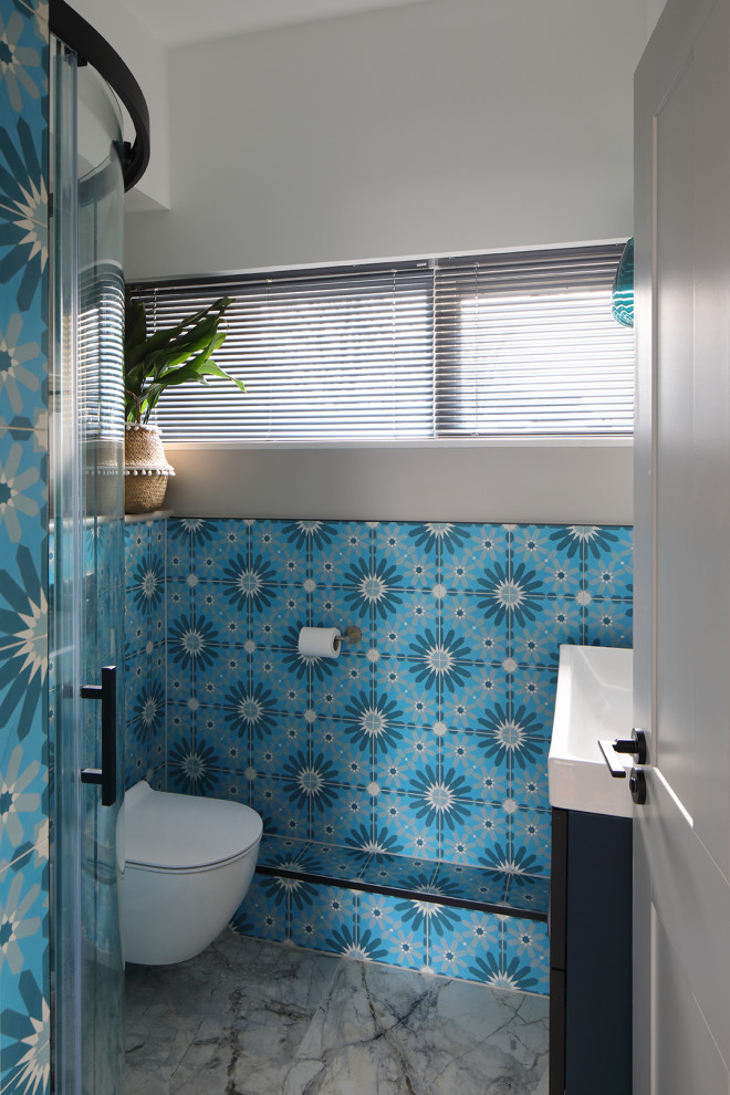 Kleines Modernes Badezimmer mit blauen Schränken, blauen Fliesen, Zementfliesen und Einzelwaschbecken in London