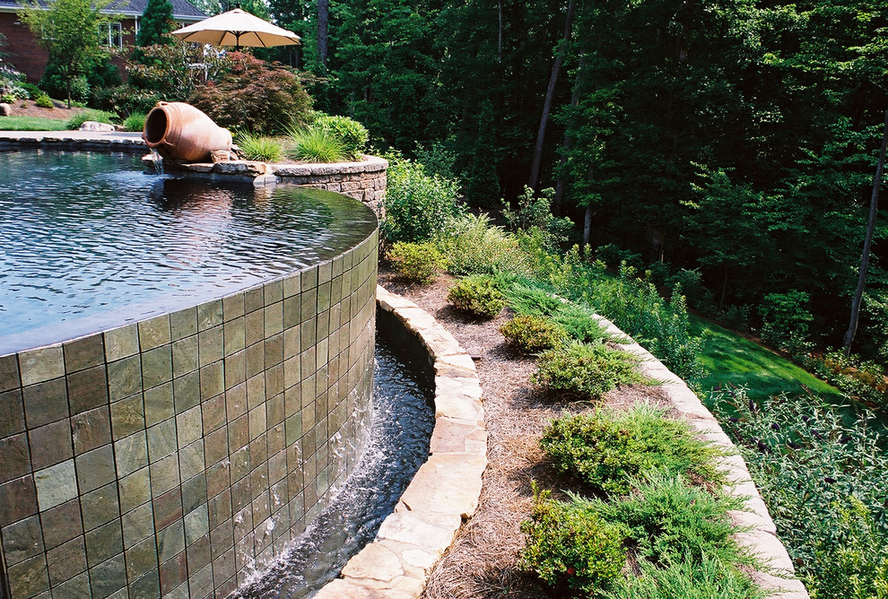 Pool fountain - mid-sized backyard concrete paver and custom-shaped infinity pool fountain idea