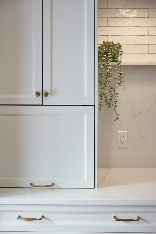 Inspiration for a large transitional single-wall medium tone wood floor and brown floor eat-in kitchen remodel in Ottawa with a farmhouse sink, white cabinets, quartz countertops, white backsplash, quartz backsplash, stainless steel appliances, an island, white countertops and shaker cabinets