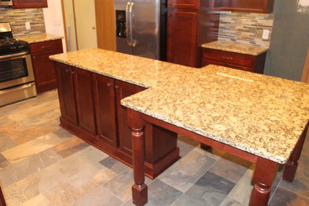 Mid-sized transitional l-shaped porcelain tile and multicolored floor eat-in kitchen photo with an undermount sink, shaker cabinets, dark wood cabinets, granite countertops, multicolored backsplash, glass tile backsplash, stainless steel appliances and an island