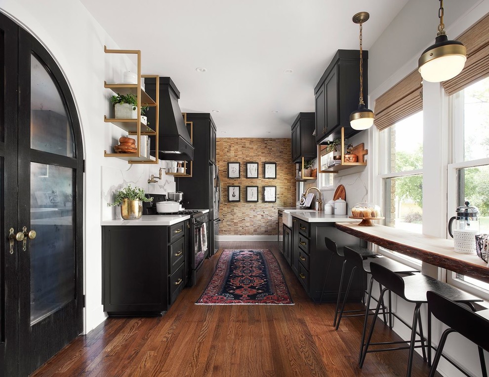 Inspiration for a transitional galley kitchen in DC Metro with a farmhouse sink, shaker cabinets, black cabinets, white splashback, medium hardwood floors and no island.