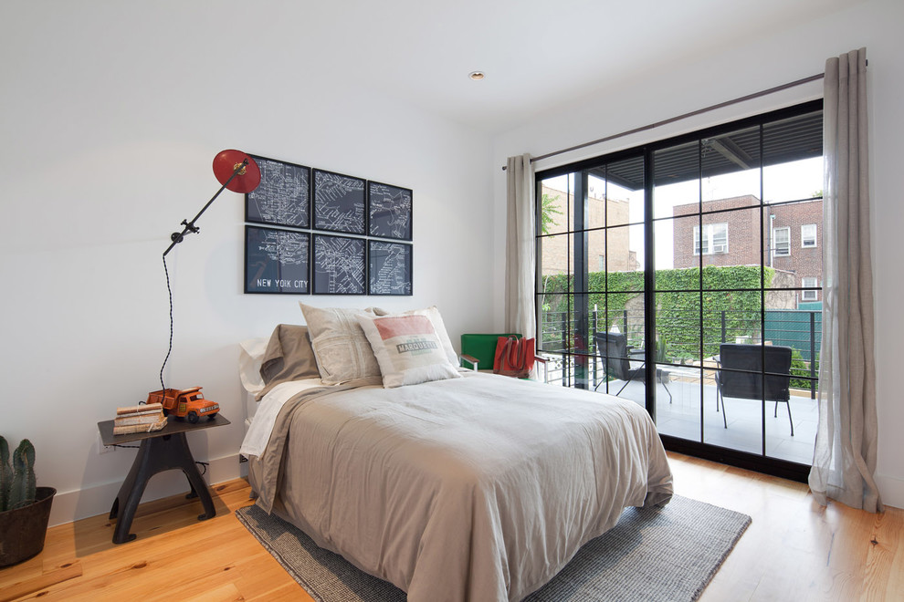 Mid-sized contemporary master bedroom in New York with white walls and light hardwood floors.
