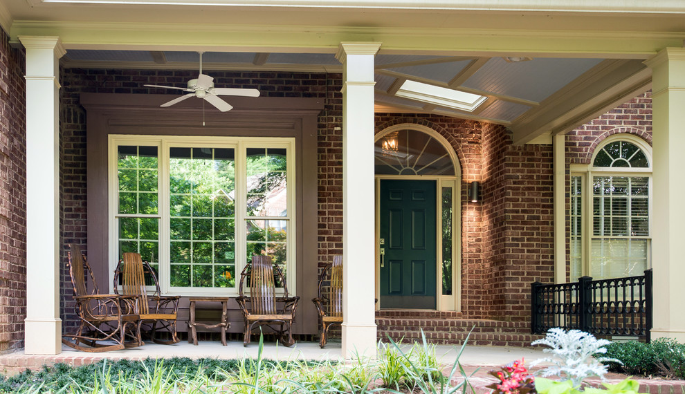 Inspiration for a mid-sized traditional front yard verandah in Atlanta with brick pavers and a roof extension.