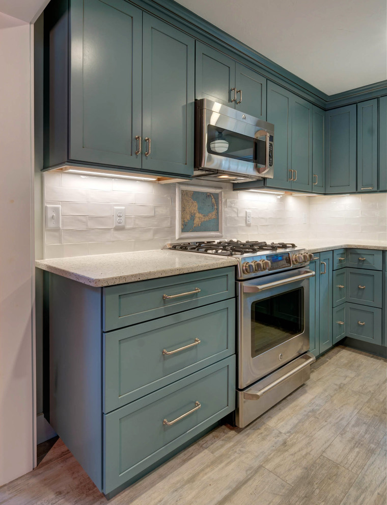 Design ideas for a small modern l-shaped kitchen pantry in Boston with a farmhouse sink, shaker cabinets, blue cabinets, recycled glass benchtops, white splashback, ceramic splashback, stainless steel appliances, ceramic floors, with island and beige floor.