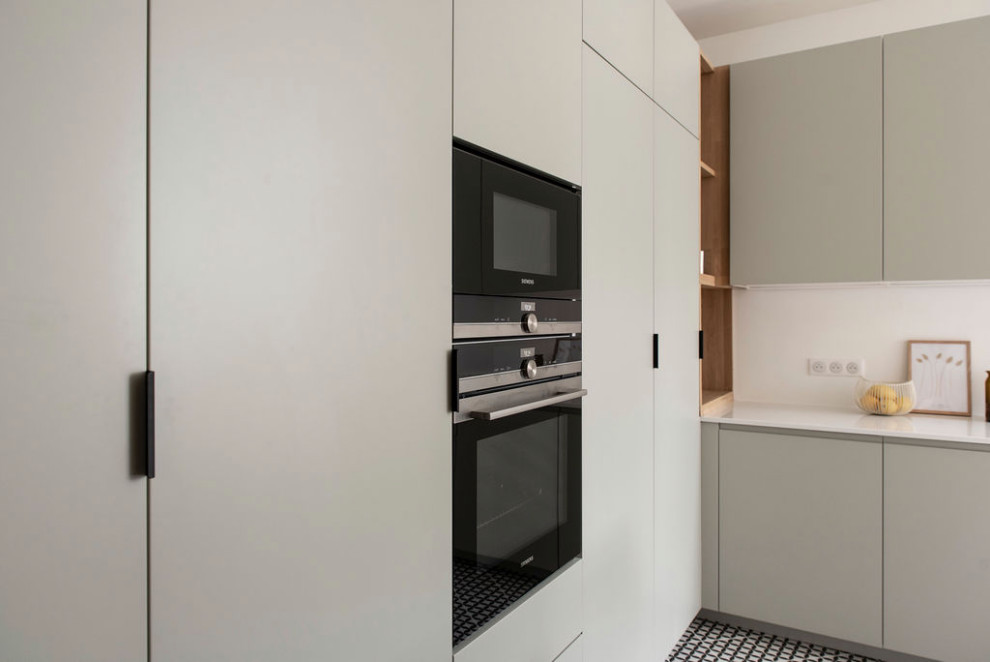 Réalisation de cuisine américaine in L With un évier encastré, un plan de travail en quartz, une crédence blanche, une crédence en quartz modifié, carreaux de ciment au sol, îlot, un sol multicolore, un plan de travail blanc and fenêtre au-dessus de l'évier.