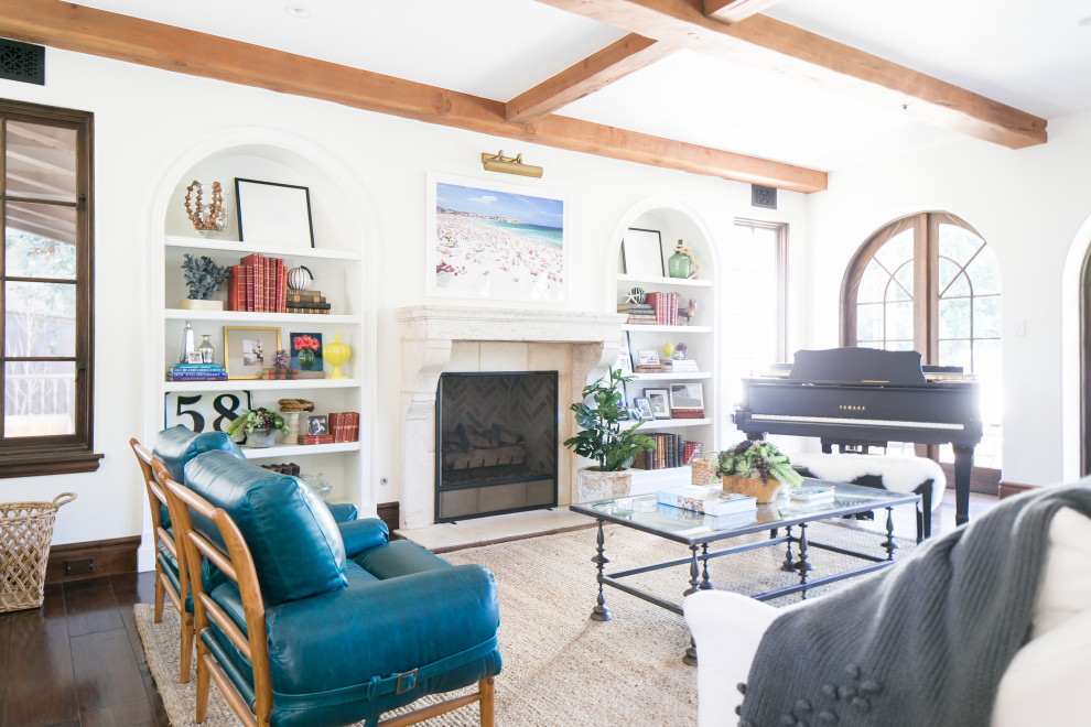 Living room - mediterranean dark wood floor and brown floor living room idea in Orange County with a music area, white walls, a standard fireplace and a stone fireplace