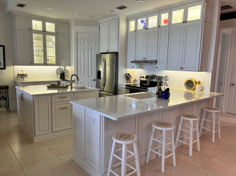 Mid-sized transitional u-shaped eat-in kitchen photo with an undermount sink, raised-panel cabinets, white cabinets, quartz countertops, multicolored backsplash, mosaic tile backsplash, stainless steel appliances, an island and multicolored countertops