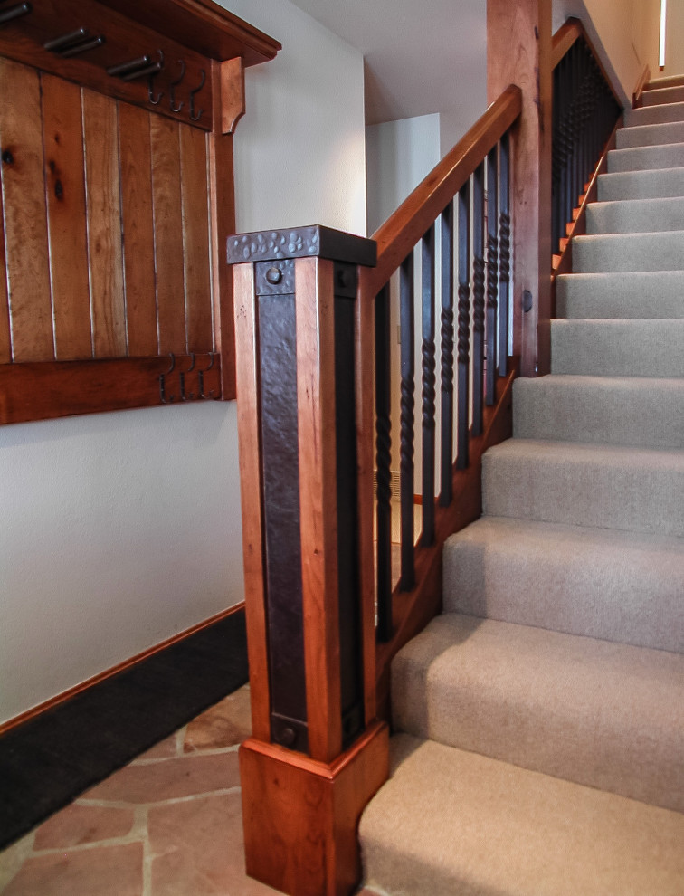 This is an example of a country carpeted straight staircase in Salt Lake City with carpet risers and metal railing.