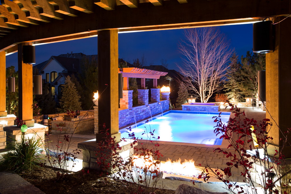 Mid-sized mountain style backyard stone and rectangular pool photo in Denver