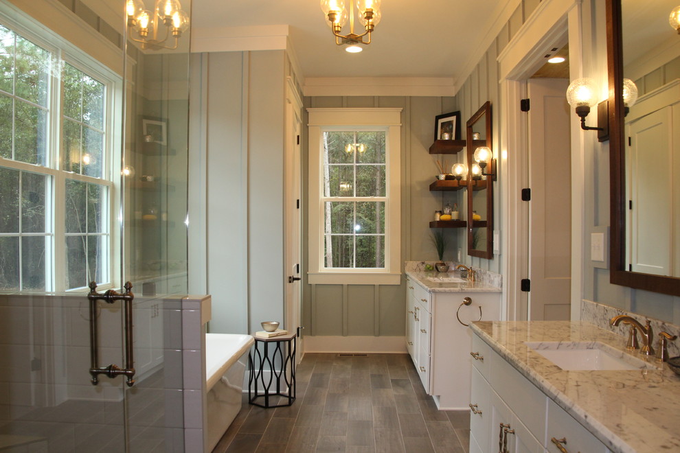 Design ideas for a country master bathroom in Raleigh with shaker cabinets, white cabinets, a freestanding tub, grey walls, an undermount sink, brown floor and a hinged shower door.