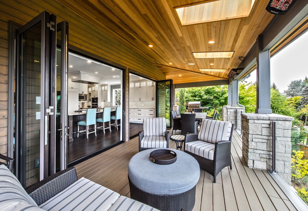 Photo of a large transitional backyard deck in Seattle with a roof extension.