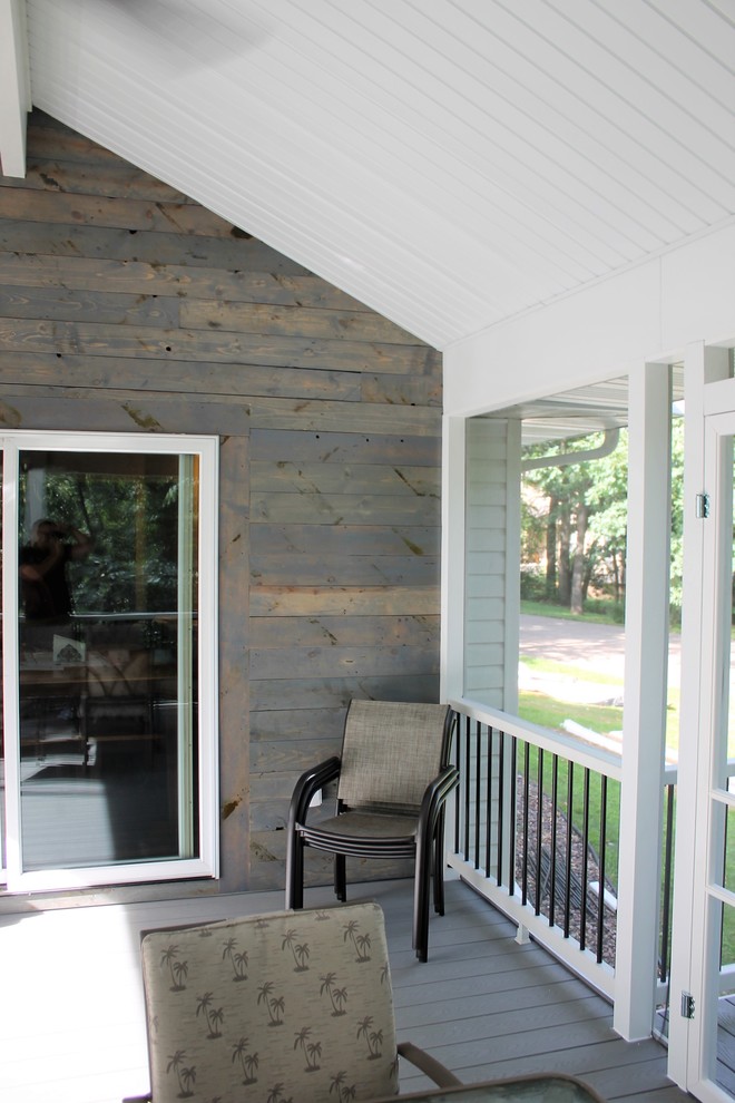 This is an example of a mid-sized country backyard deck in Other with a roof extension.
