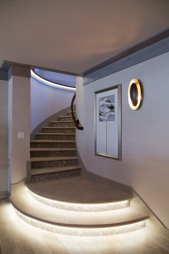 This is an example of a mid-sized transitional concrete curved staircase in Kansas City with tile risers.