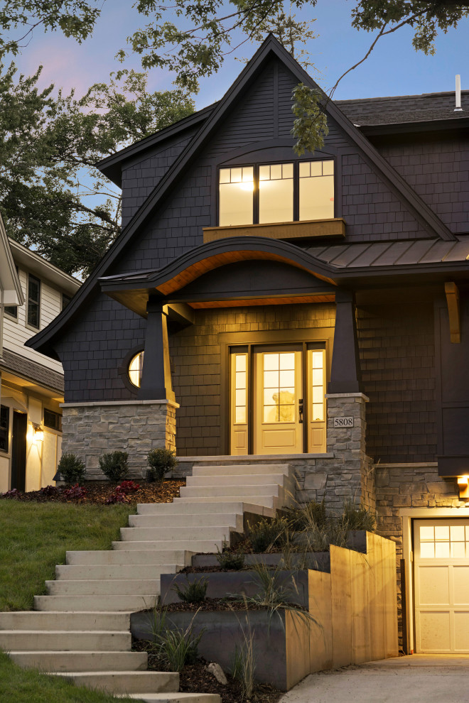 Photo of a large traditional two-storey black house exterior in Minneapolis with a shingle roof, a black roof and shingle siding.