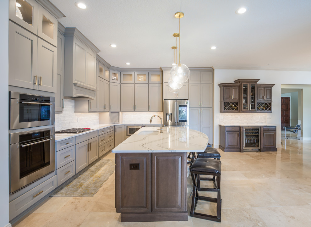 Inspiration for a mid-sized transitional l-shaped eat-in kitchen in Jacksonville with an undermount sink, recessed-panel cabinets, quartz benchtops, white splashback, marble splashback, stainless steel appliances, with island, multi-coloured floor, white benchtop, beige cabinets and marble floors.