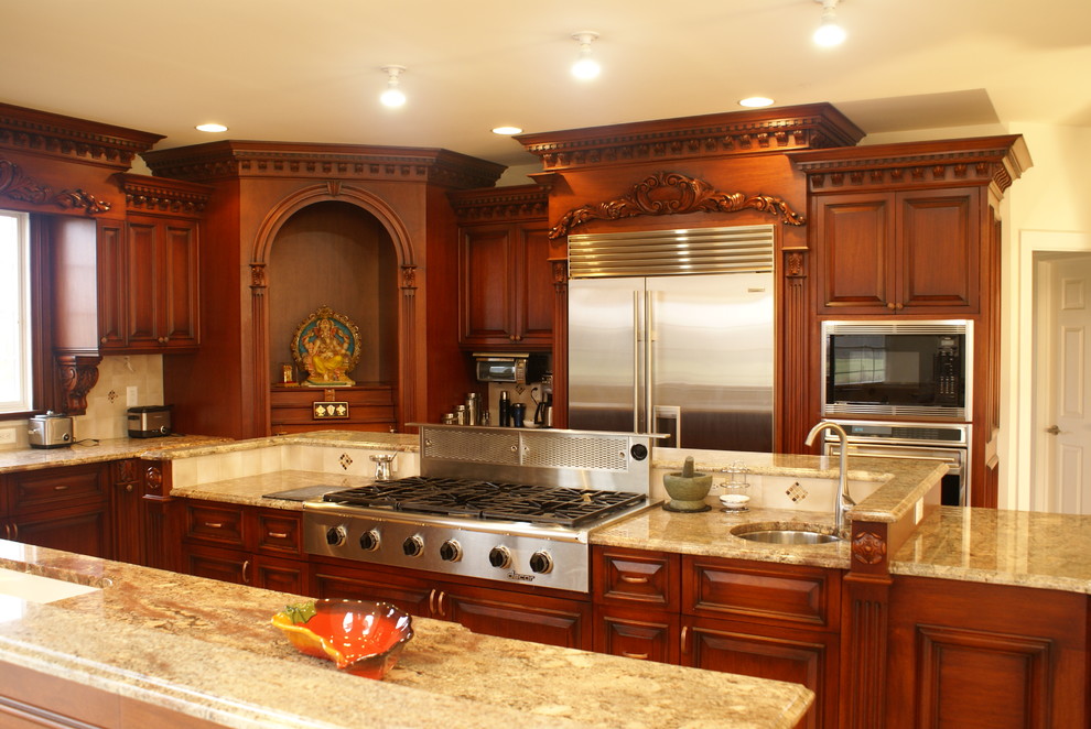 Traditional kitchen in Newark with stainless steel appliances, raised-panel cabinets and dark wood cabinets.