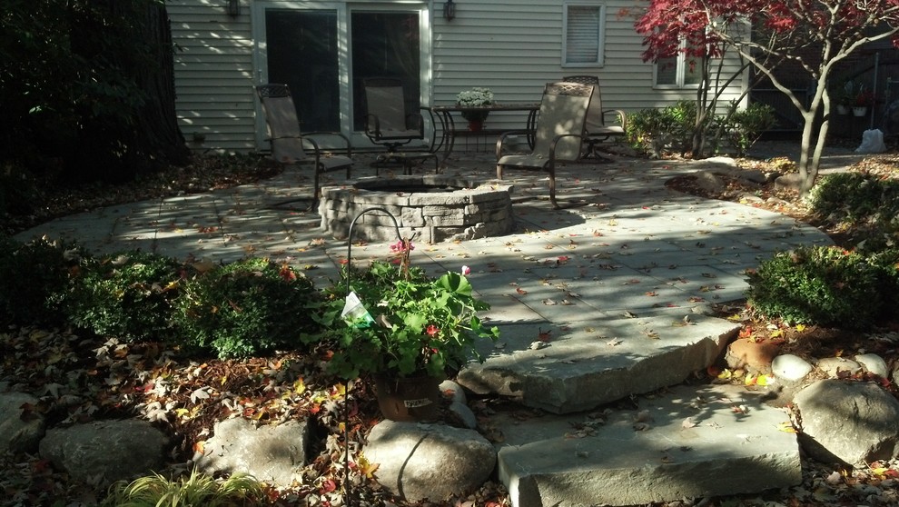 Foto de patio actual con brasero y adoquines de piedra natural