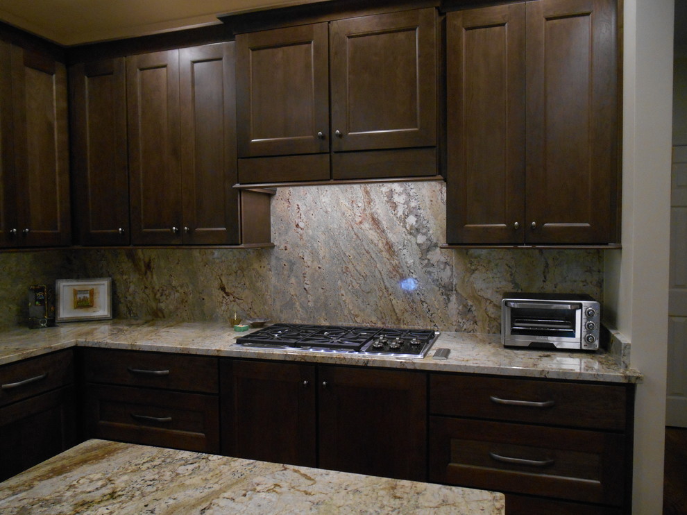 Example of a mid-sized transitional l-shaped medium tone wood floor eat-in kitchen design in Birmingham with a single-bowl sink, flat-panel cabinets, medium tone wood cabinets, granite countertops, stone slab backsplash, paneled appliances, beige walls and an island