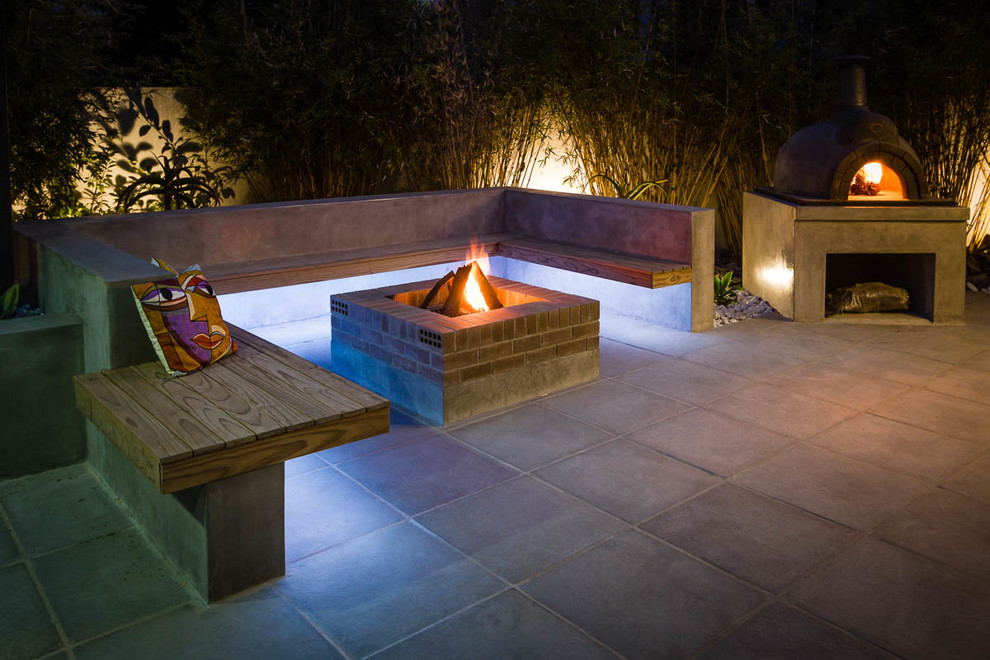 This is an example of a small contemporary backyard patio in Other with concrete pavers.