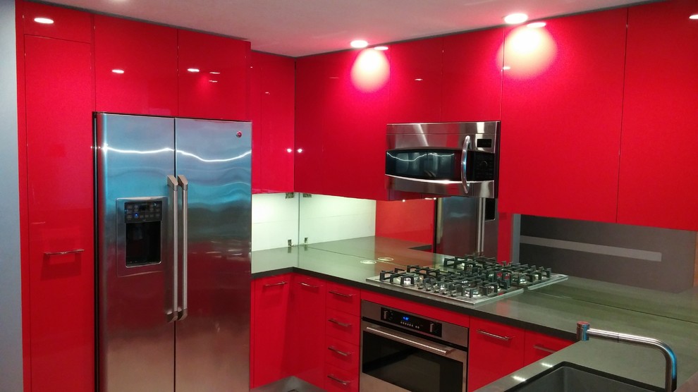 Inspiration for a small modern u-shaped eat-in kitchen in San Diego with flat-panel cabinets, red cabinets, quartz benchtops, metallic splashback, glass sheet splashback, stainless steel appliances, a peninsula, an undermount sink and light hardwood floors.