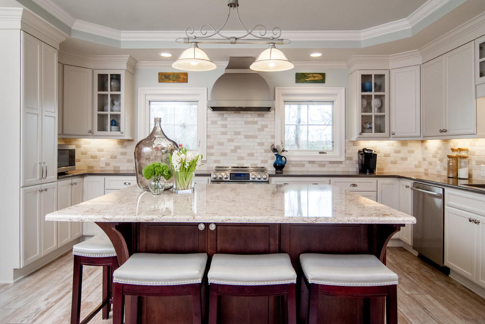 Inspiration for a large traditional u-shaped open plan kitchen in New Orleans with quartz benchtops, with island, a double-bowl sink, flat-panel cabinets, white cabinets, beige splashback, stainless steel appliances, subway tile splashback, porcelain floors, grey floor, white benchtop and recessed.