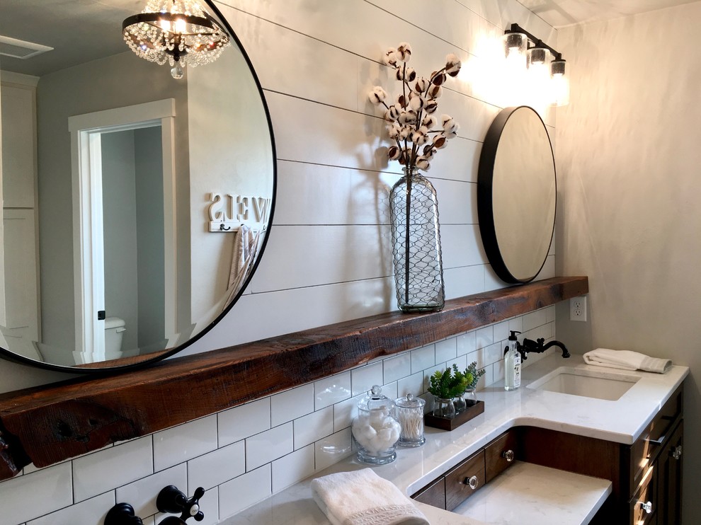 Inspiration for a mid-sized country master bathroom in Other with dark wood cabinets, an alcove shower, a one-piece toilet, grey walls, ceramic floors, a drop-in sink, marble benchtops, black floor, a hinged shower door and recessed-panel cabinets.