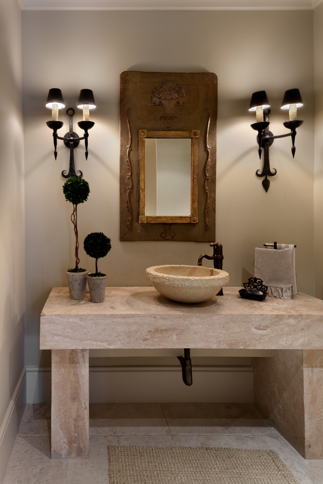 This is an example of a mid-sized mediterranean powder room in Houston with a vessel sink, beige walls, beige tile, travertine floors and beige benchtops.