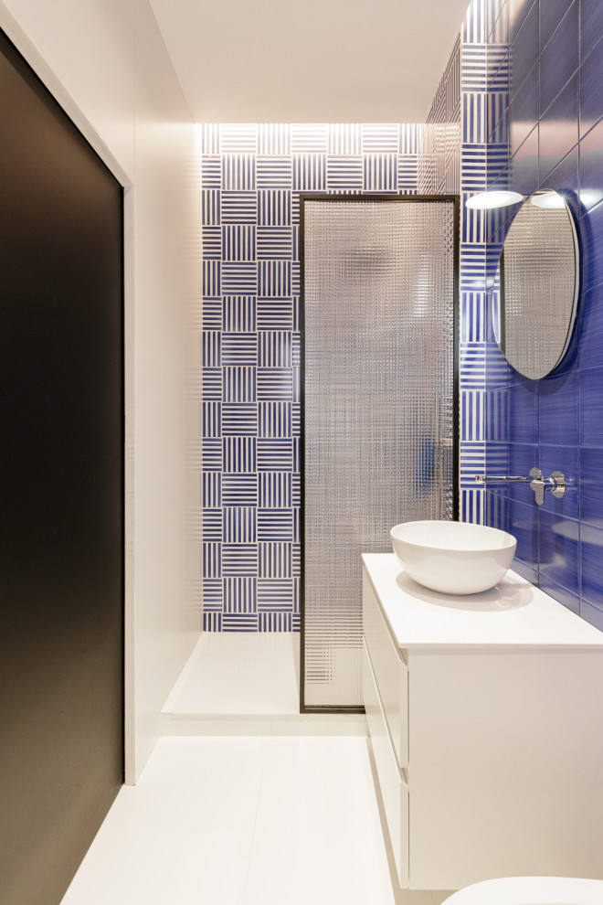 Стильный дизайн: большая ванная комната в современном стиле с белыми фасадами, синей плиткой, керамической плиткой, черными стенами, настольной раковиной, столешницей из ламината, белым полом, белой столешницей, подвесной тумбой, многоуровневым потолком, открытым душем, инсталляцией, полом из керамогранита, душевой кабиной, открытым душем, панелями на стенах и плоскими фасадами - последний тренд