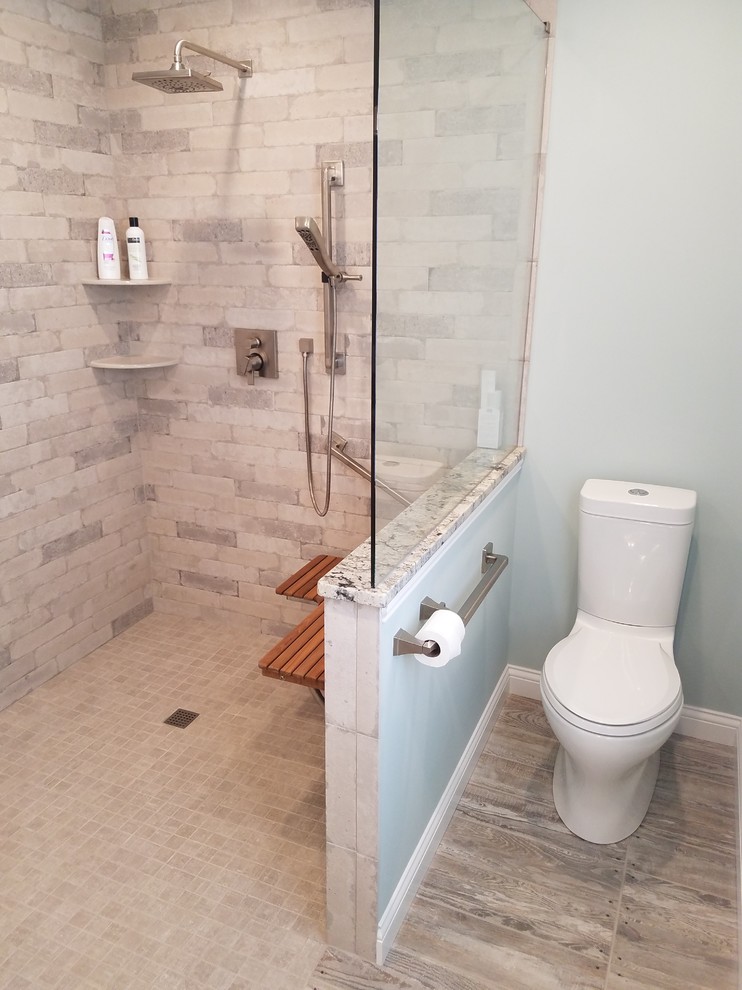 This is an example of a mid-sized arts and crafts master wet room bathroom in Cincinnati with shaker cabinets, white cabinets, a two-piece toilet, gray tile, ceramic tile, blue walls, ceramic floors, an undermount sink, granite benchtops, beige floor and an open shower.
