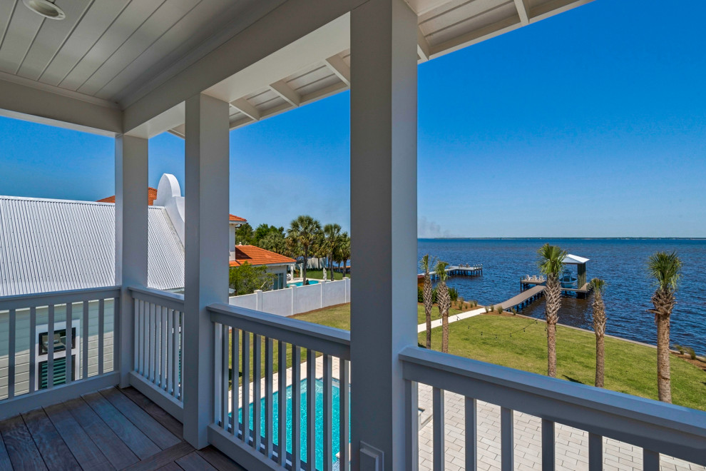 Inspiration for a mid-sized coastal wood railing balcony remodel in Other with a roof extension