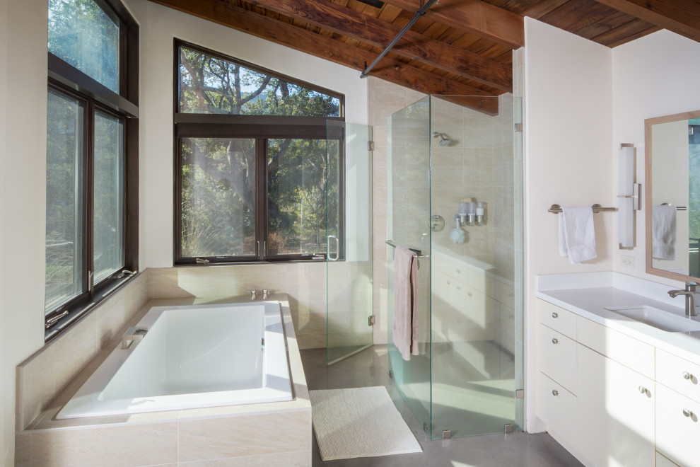 This is an example of a contemporary bathroom in Other with flat-panel cabinets, white cabinets, a drop-in tub, a curbless shower, white walls, an undermount sink, grey floor, a hinged shower door, white benchtops, a single vanity, a floating vanity, exposed beam, vaulted and wood.