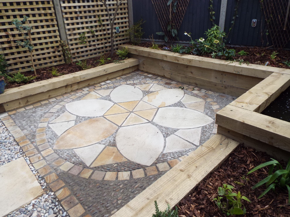 Inspiration for a small country backyard partial sun garden in Kent with natural stone pavers.