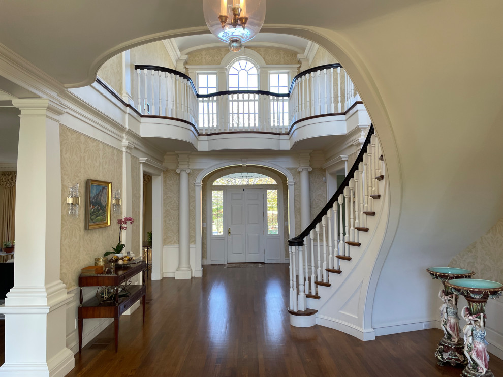 Geräumiges Klassisches Foyer mit beiger Wandfarbe, braunem Holzboden, Einzeltür, weißer Haustür, braunem Boden, Kassettendecke und Tapetenwänden in Boston