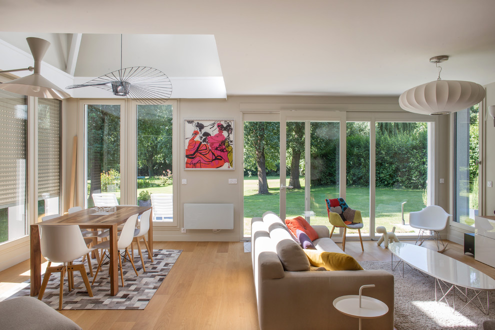 Inspiration for a scandinavian open concept living room in Paris with beige walls, light hardwood floors and brown floor.